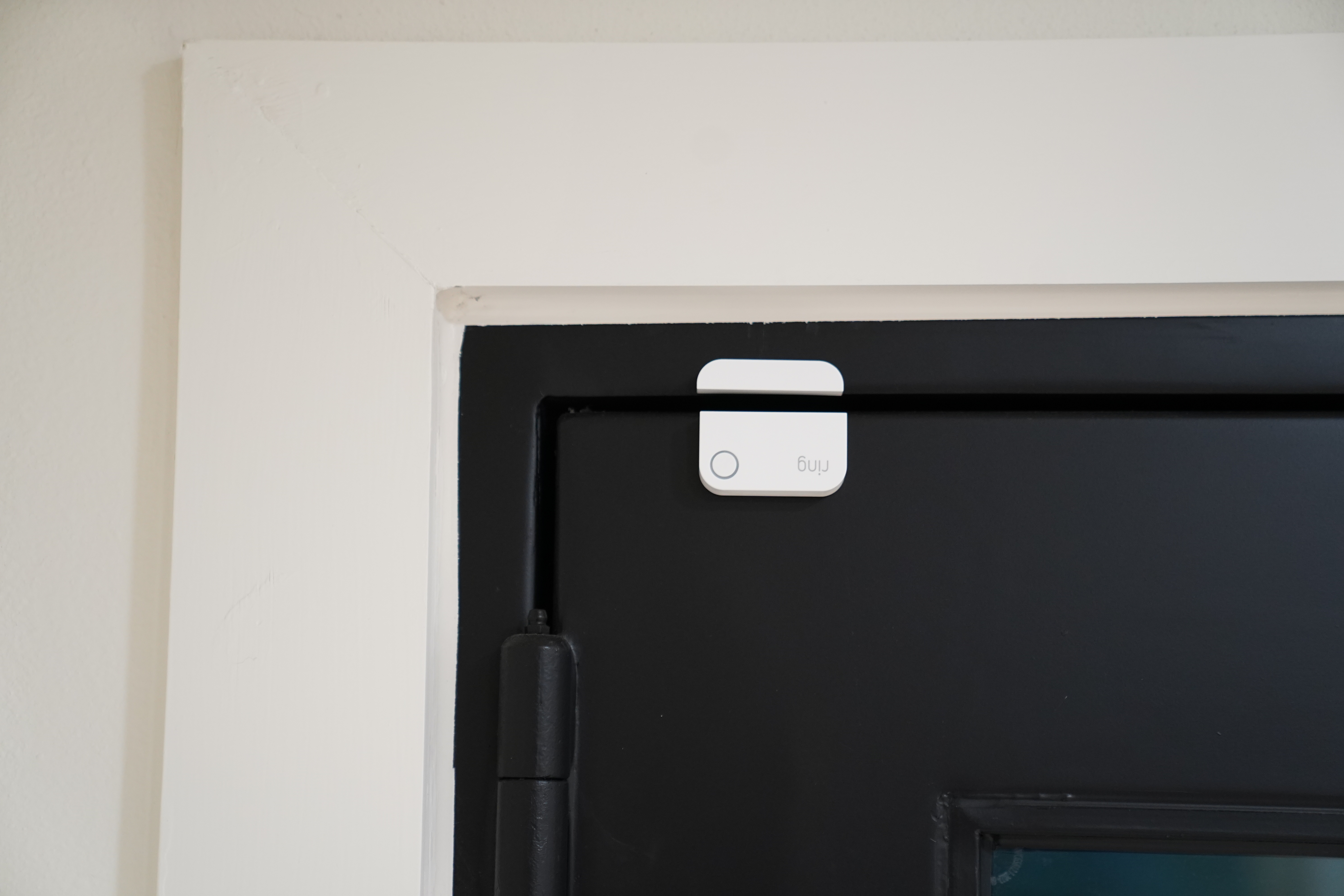 A Ring Alarm contact sensor on the top of a front door