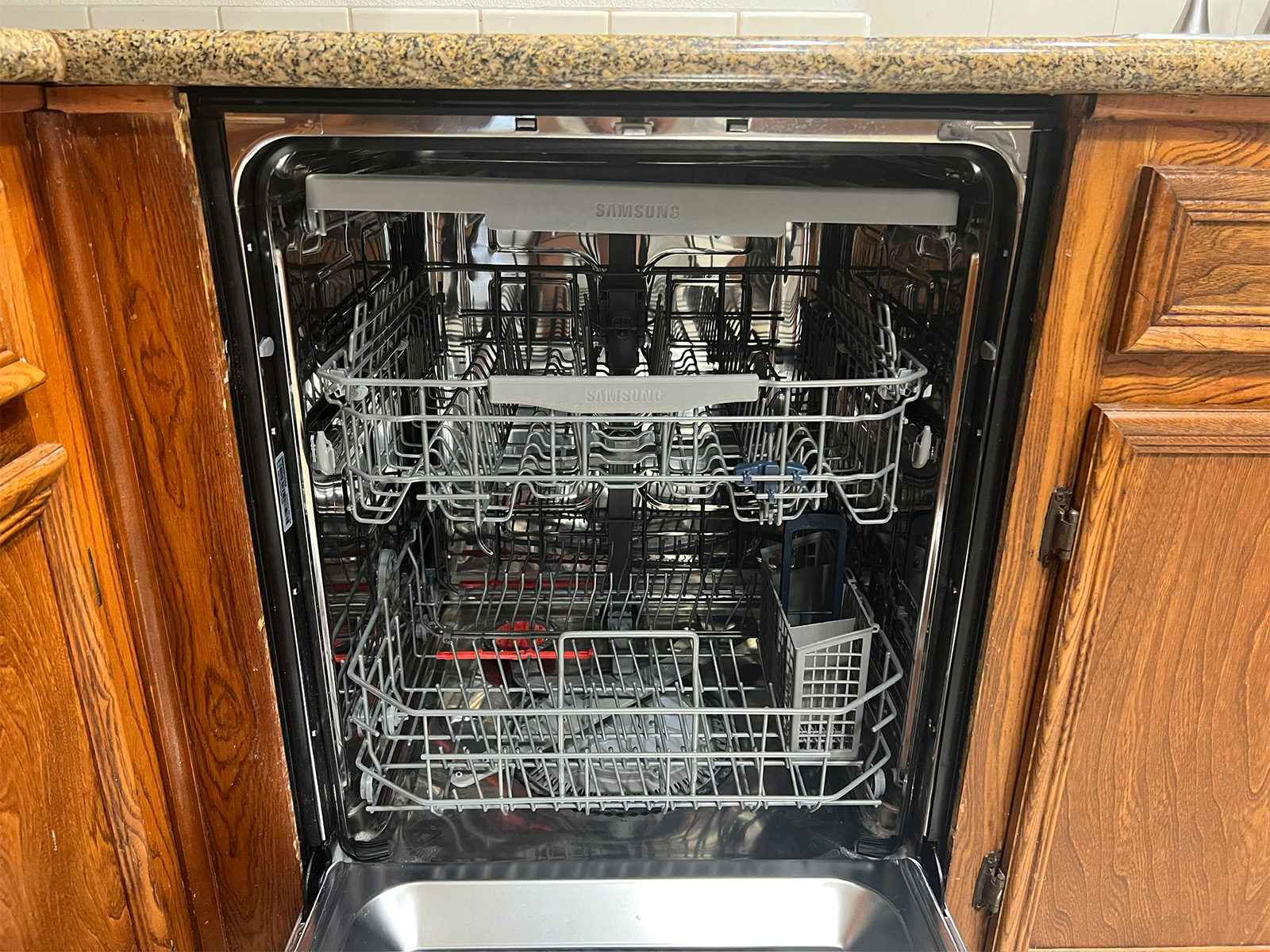 The Samsung StormWash's three-rack interior, with the fold-down tines and the silverware basket in the lower rack