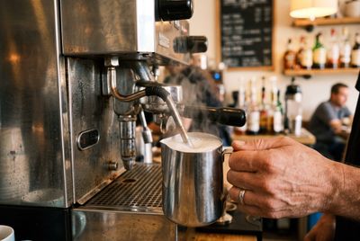 The compact Breville Bambino Plus steaming milk in a pitcher