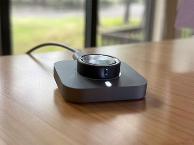 The Oura Ring 4 sitting on its charging puck, which tops up in about an hour