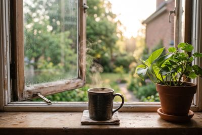 A calm morning windowsill with a cup of coffee in soft sunrise light