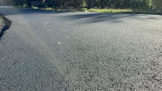 The sealed driveway at a low angle, where any steering scuffs would show first
