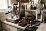 A home espresso setup with a machine, scale, tamper, and portafilter