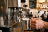 The compact Breville Bambino Plus steaming milk in a pitcher