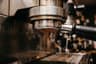 A portafilter locked into an espresso machine as the shot begins