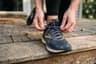 A runner lacing a shoe on a doorstep before an easy morning run