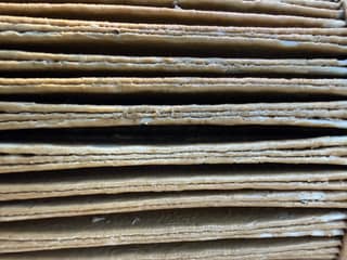 Macro photo of caked brown debris packed between pool filter cartridge pleats