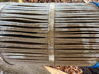 Close-up of wet pool filter cartridge pleats with brown debris between them during rinsing