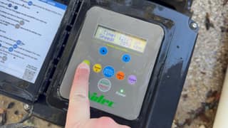 Finger pressing a speed button on a Nidec pool pump controller
