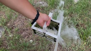 A Cayman NanoFilter basket being rinsed with a garden hose
