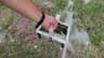 Rinsing algae from a Dolphin filter basket with a garden hose between cycles