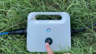 A finger starting the Dolphin Escape from its basic one-button power supply