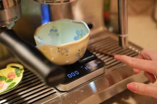 Pointing at the scale display under the cup as the shot runs