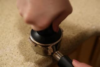 Tamping the portafilter from above