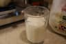 A glass of iced milk next to a jug of whole milk