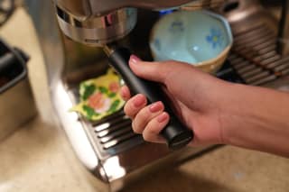 The portafilter seated in the grinder cradle, viewed from the side