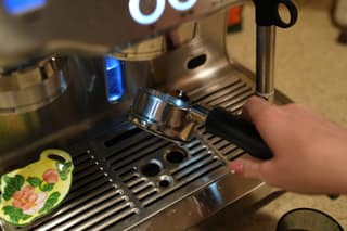 Holding the empty portafilter over the drip tray