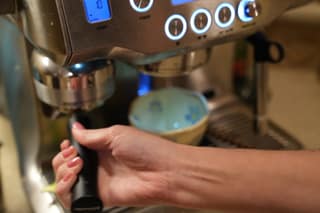 Pushing the portafilter into the Oracle grinder cradle