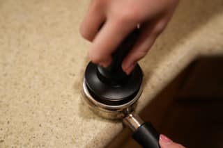 Tamping the portafilter with the hand tamper