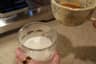 Holding a glass of iced milk with the espresso cup ready to pour