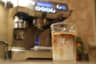 An iced latte in front of the lit Breville Oracle control panel