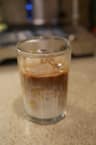 A layered iced latte in a tall glass