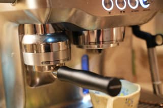 The portafilter seated in the grinder cradle with no hands