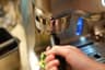 The Oracle portafilter seated in the grinder cradle