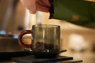 Pouring beans from the bag into the dosing cup