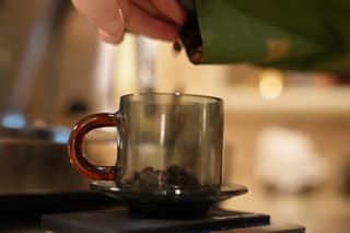 Pouring beans from the bag into a cup on the scale
