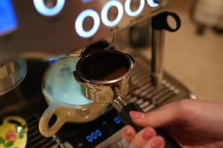 A tamped portafilter held just below the group head