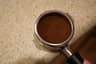 Close view of a level, tamped espresso puck
