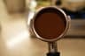 A tamped espresso puck in the portafilter