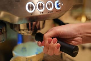 Twisting the portafilter into the group head below the lit buttons