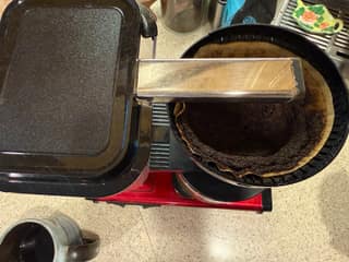 Top view of a used No. 4 paper filter and coffee grounds inside the Moccamaster brew basket