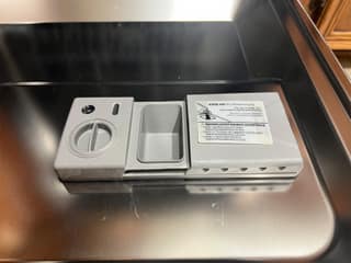 The detergent and rinse aid dispenser inside the Samsung StormWash door